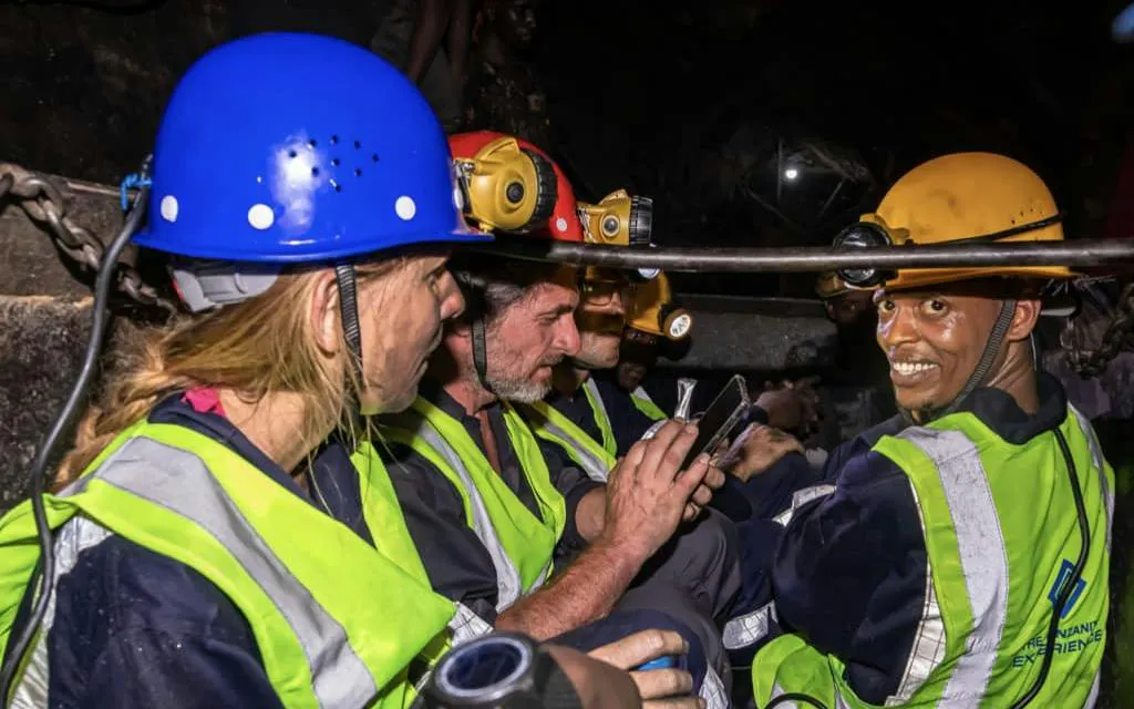 Tourists in safety gear exploring Mererani Tanzanite Mine, Tanzania.