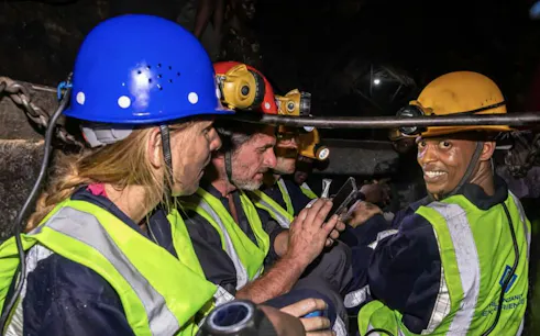 Tourists in safety gear exploring Mererani Tanzanite Mine, Tanzania.