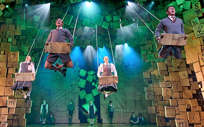 Performers on swings during a scene from Matilda The Musical.