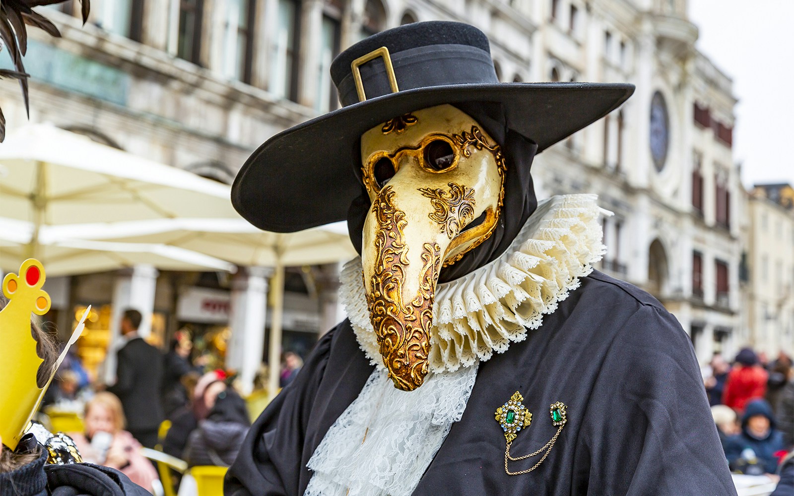 Venice Carnival attendees wearing traditional Plague Doctor masks in a vibrant street setting.