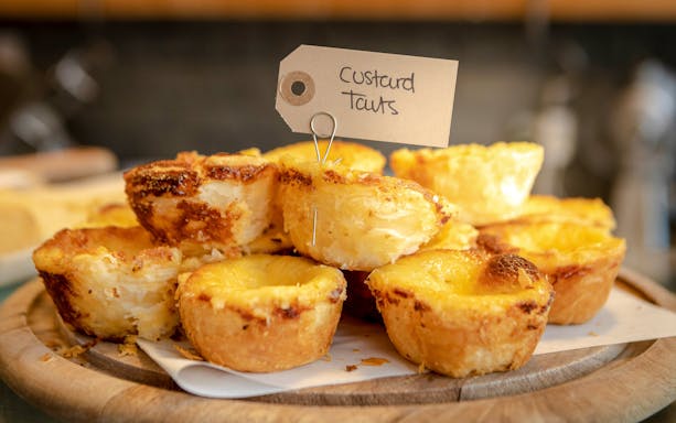 Pile of custard tarts on a plate during Glasgow food tour.