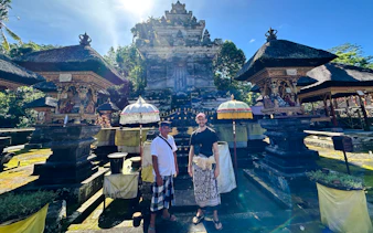 Local guide and visitor at Gunung Kawi Sebatu temple, Bali, with traditional shrines.
