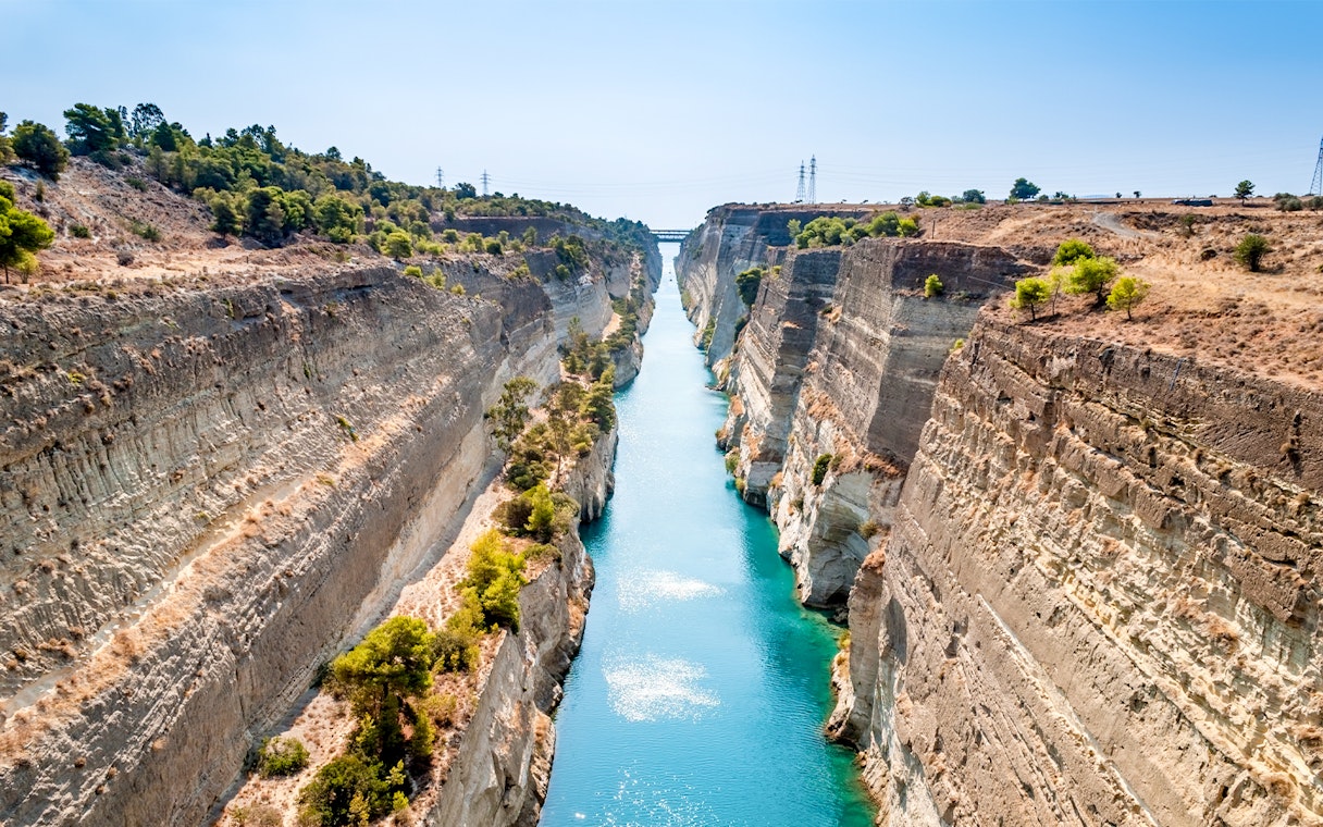 Corinth Canal with turquoise water between steep cliffs in Greece.