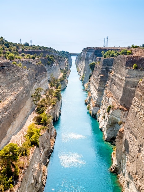 Corinth Canal with turquoise water between steep cliffs in Greece.