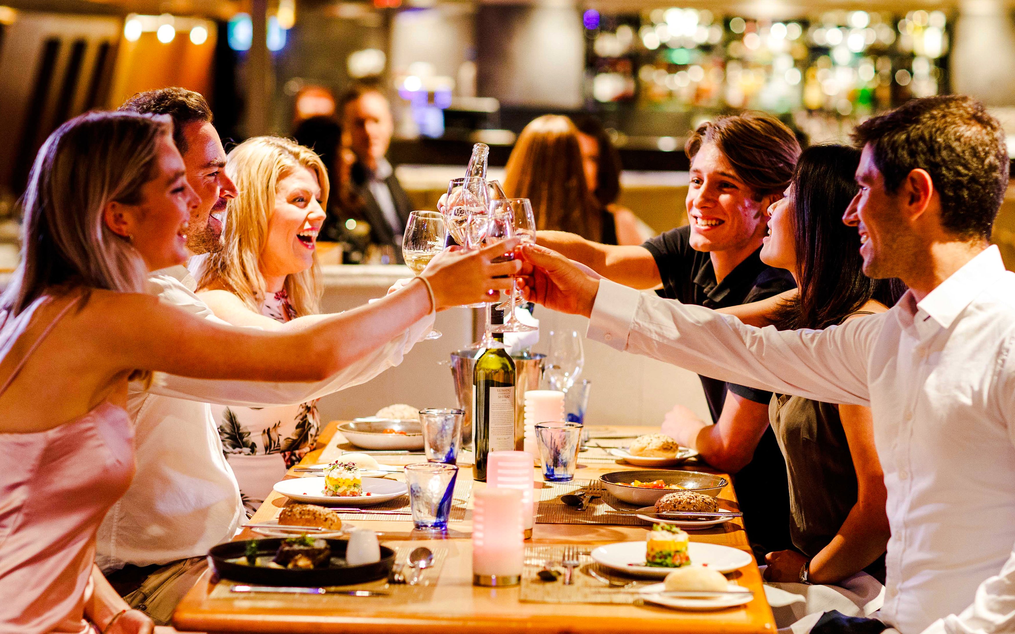 Guests toasting during Vivid Sydney Sunset Cruise dinner.
