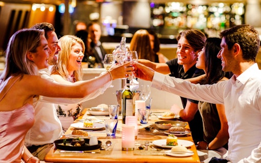 Guests toasting during Vivid Sydney Sunset Cruise dinner.
