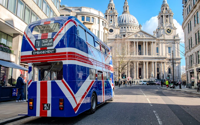 Double-decker bus with Union Jack design near St. Paul's Cathedral, Central London.