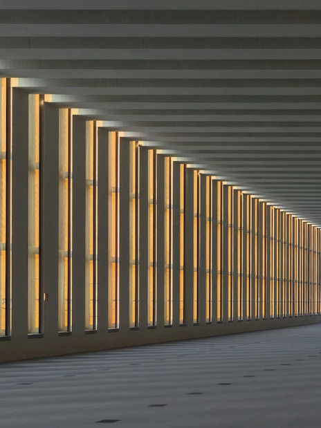 Interior of Royal Collections Gallery with illuminated vertical windows.