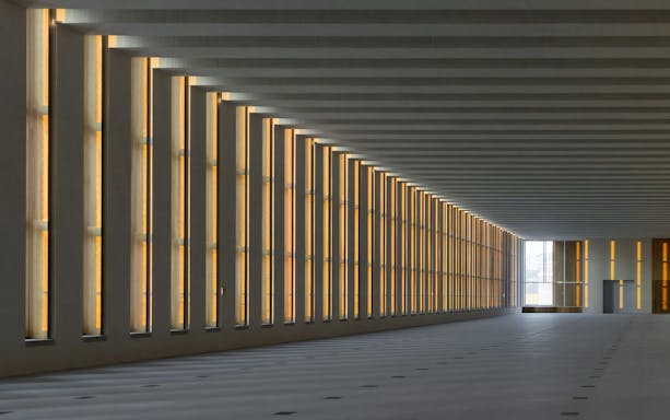 Interior of Royal Collections Gallery with illuminated vertical windows.