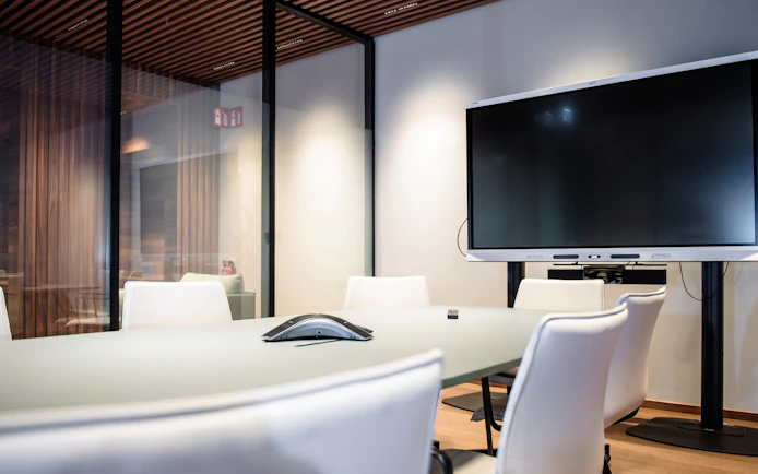 Meeting room with conference table and screen at BER Lounge Tegel, Berlin Brandenburg Airport Terminal 1.