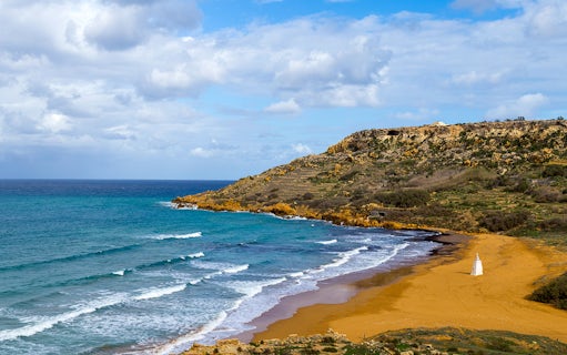 Gozo coastline with waves and sandy beach, part of the Gozo Jeep Tour.