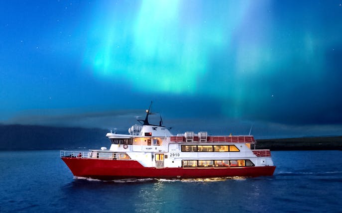 Cruise ship under Northern Lights near Reykjavik, Iceland.