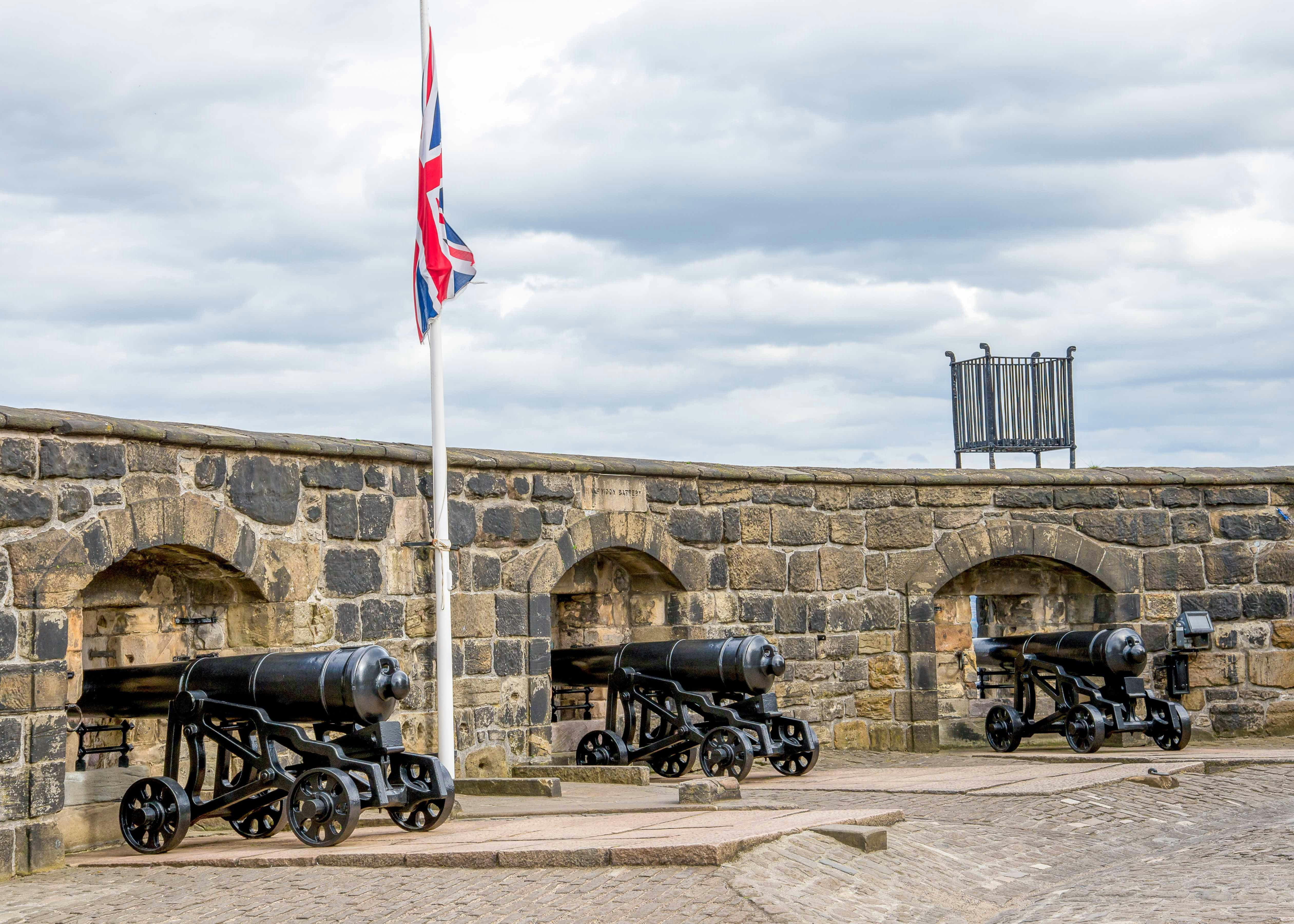 Cannons at The Half Moon Battery, Edinburgh Castle, with a British flag.