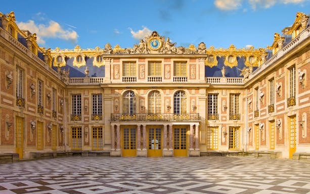 Guided tour group exploring the Hall of Mirrors in Versailles Palace, Paris.
