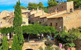 Stone buildings and greenery in the historic town of Tossa de Mar, Spain.