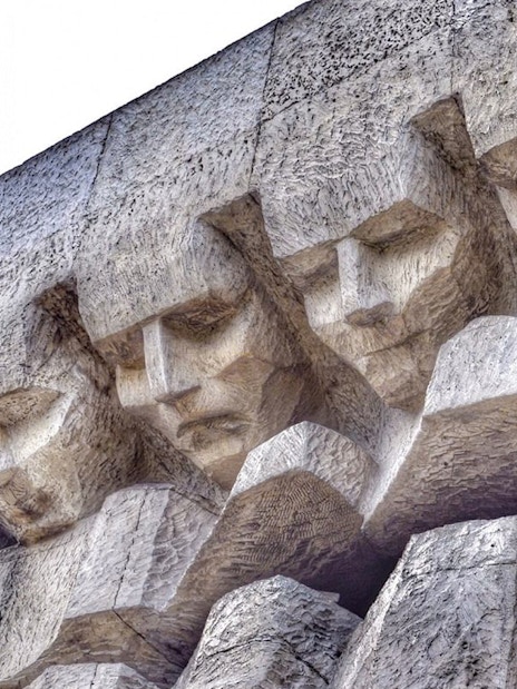 Close-up of carved faces on the Monument to the Victims of Fascism Plaszow, Krakow.