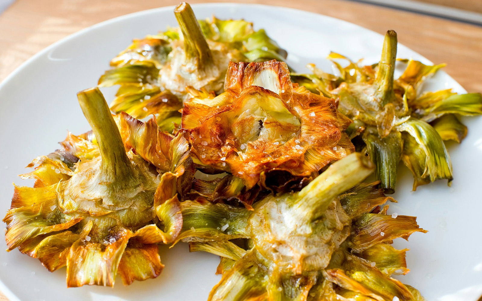 Carciofo alla Giudia, fried artichokes, on a plate in Rome, showcasing kosher cuisine.