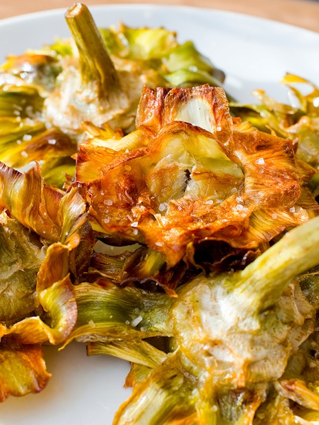 Carciofo alla Giudia, fried artichokes, on a plate in Rome, showcasing kosher cuisine.