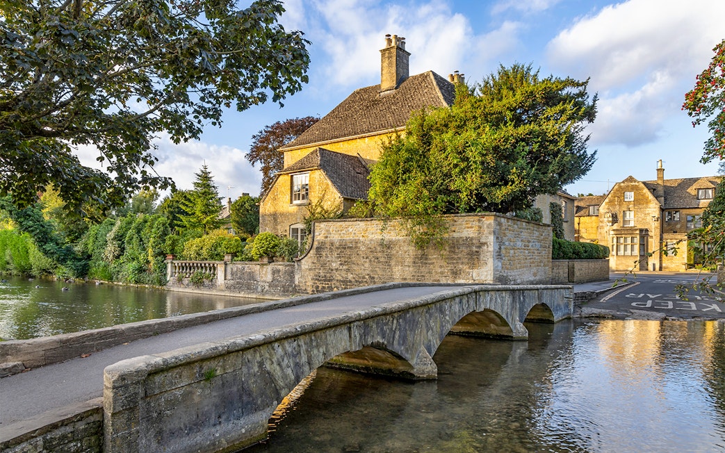 Stone bridge and historic house in a Cotswolds village, part of Blenheim Palace and Downton Abbey tour.