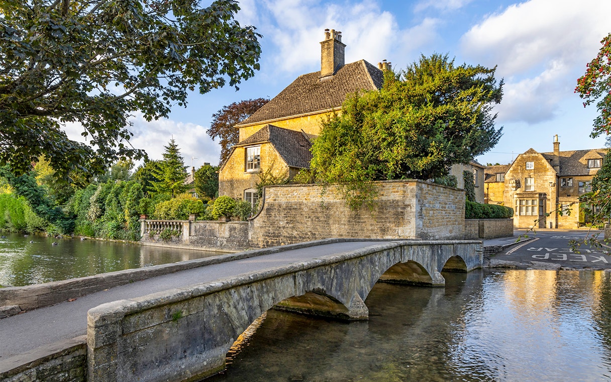 Stone bridge and historic house in a Cotswolds village, part of Blenheim Palace and Downton Abbey tour.