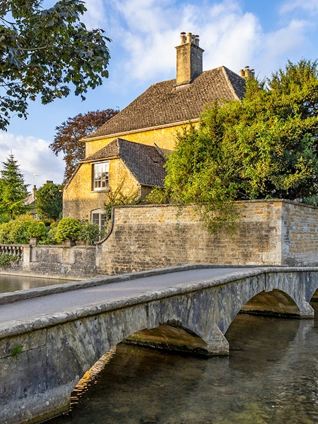 Stone bridge and historic house in a Cotswolds village, part of Blenheim Palace and Downton Abbey tour.
