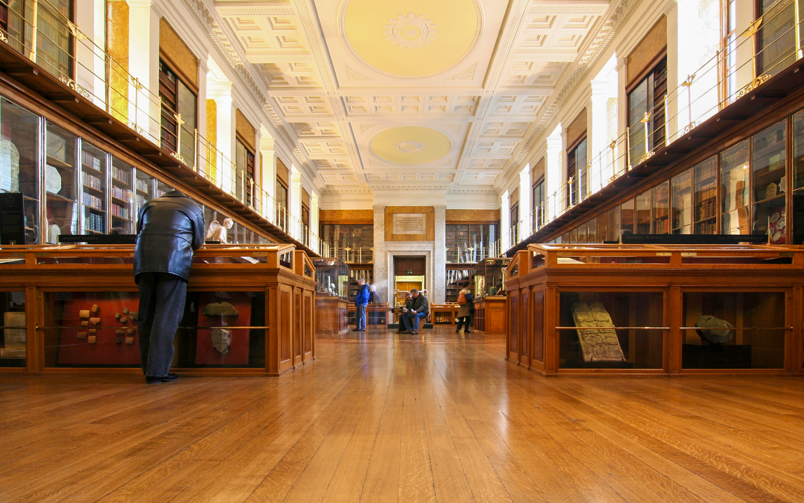 British Museum study room with ancient artifacts and visitors exploring exhibits.