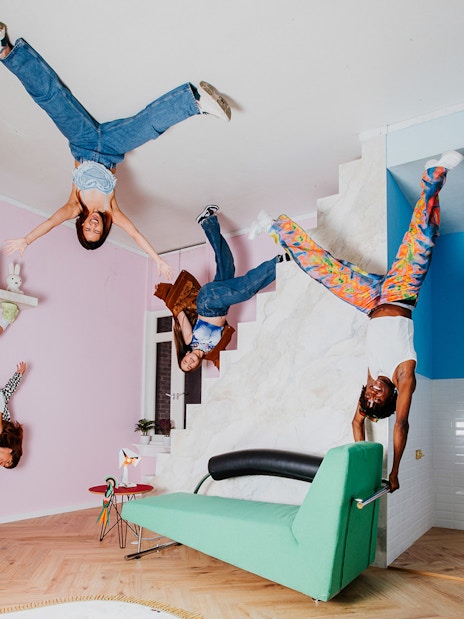 Visitors exploring the Upside Down Amsterdam exhibit with inverted furniture and decor.