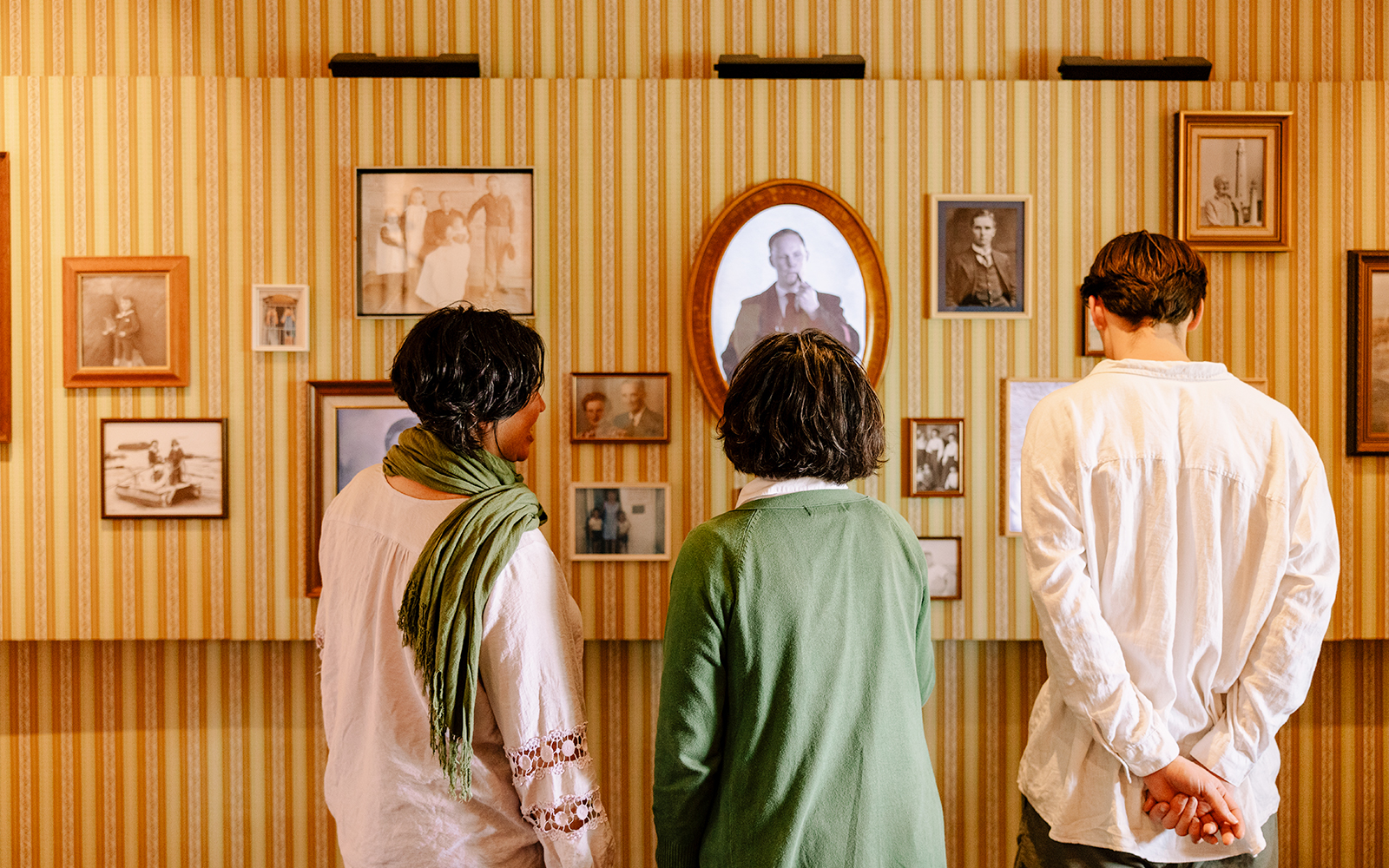 Visitors examining historical photographs at Cape Leeuwin Lighthouse exhibit.