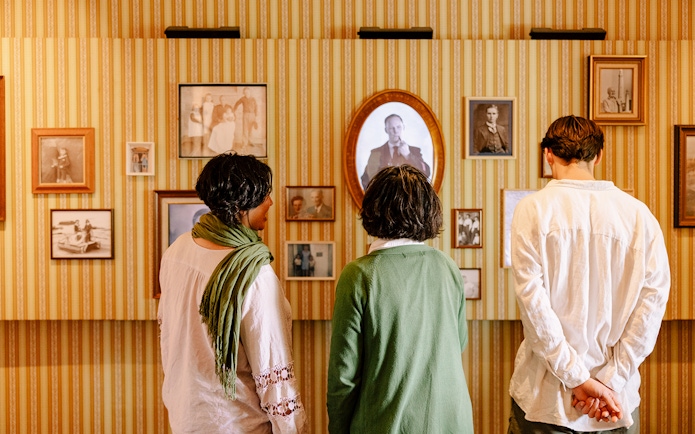 Visitors examining historical photographs at Cape Leeuwin Lighthouse exhibit.