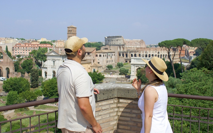 Couple admiring the Roman Forum view during a guided tour in Rome.
