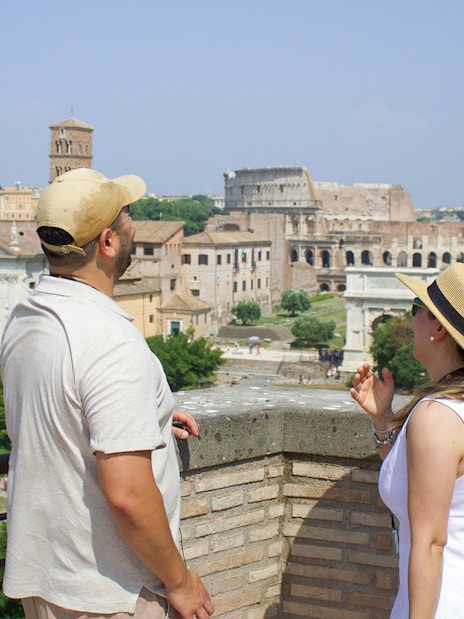 Couple admiring the Roman Forum view during a guided tour in Rome.