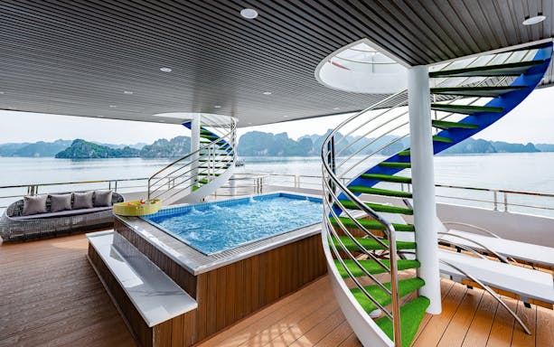 Jacuzzi on the deck of Hercules premium cruise with ocean view and spiral staircase.