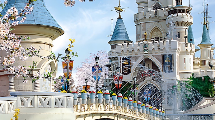 Lotte World castle with bridge and cherry blossoms in Seoul, South Korea.