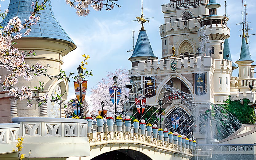 Lotte World castle with bridge and cherry blossoms in Seoul, South Korea.
