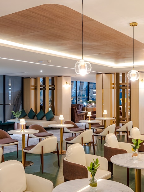 Coral Cosmo Lounge seating area with tables and chairs, Concourse C, Bangkok airport, Thailand.