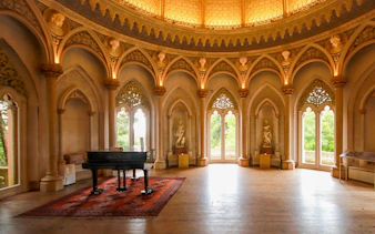 Monserrate Palace interior with grand piano and ornate arches in Sintra, Portugal.
