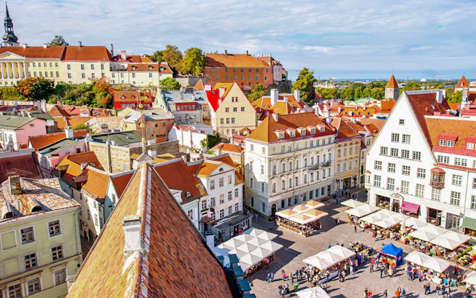 Tallinn's Old Town square with colorful medieval buildings and market stalls, Estonia.