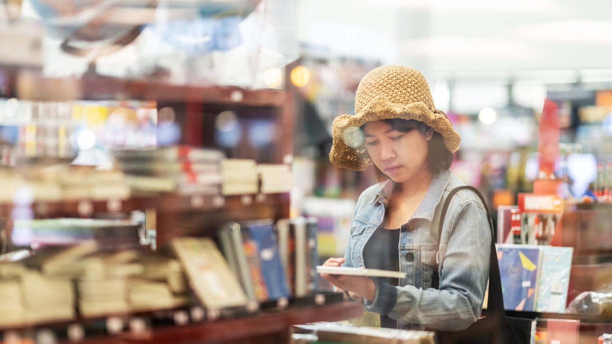 Attendees browsing books at the London Book Fair in a large exhibition hall.