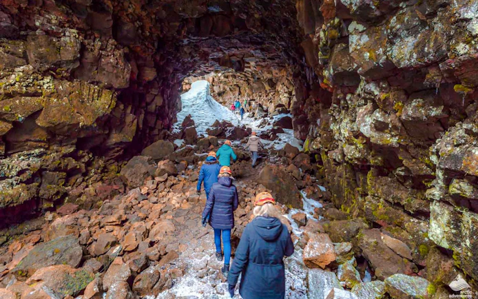 Guests walking inside Raufarhólshellir Lava Tunnel, Iceland.