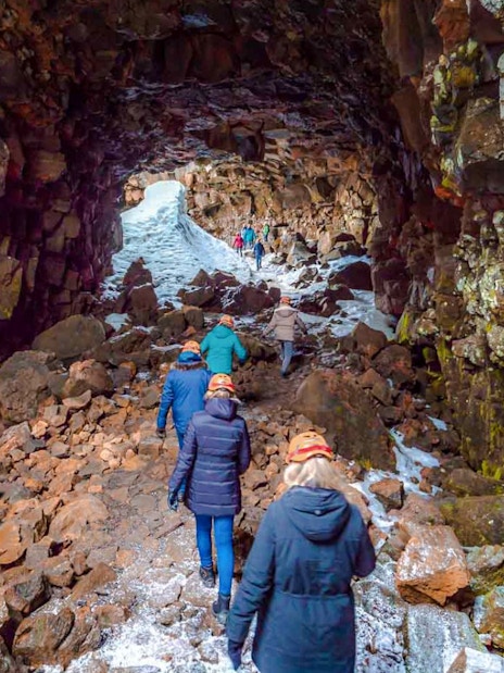 Guests walking inside Raufarhólshellir Lava Tunnel, Iceland.
