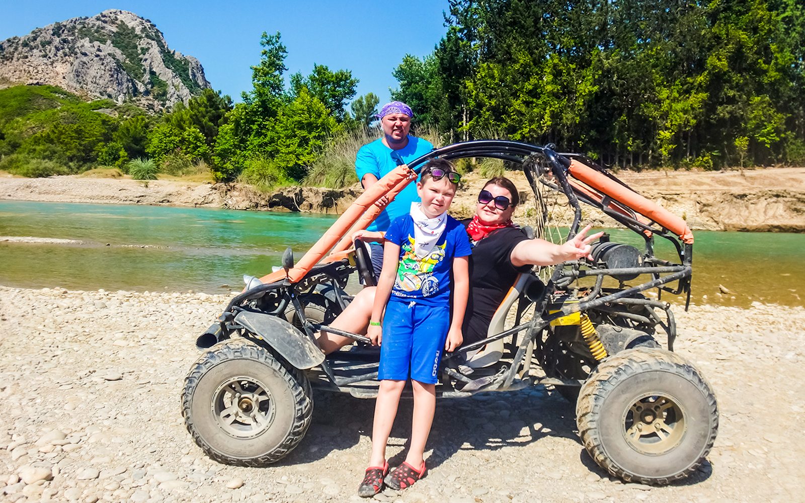Family enjoying a quad bike tour by a river in Antalya.