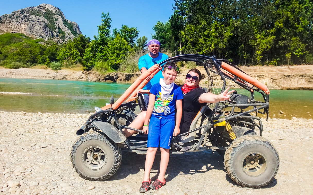 Family enjoying a quad bike tour by a river in Antalya.