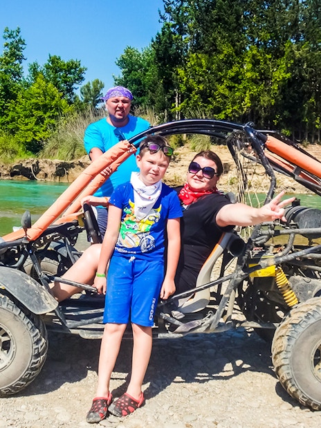 Family enjoying a quad bike tour by a river in Antalya.