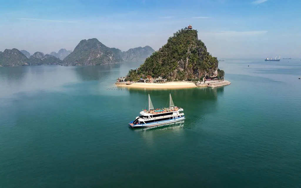 Cruise boat near limestone island in Ha Long Bay, Vietnam.