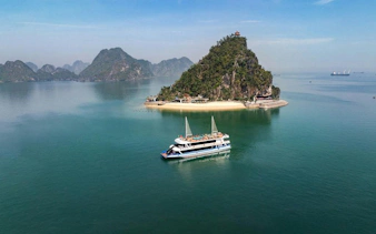 Cruise boat near limestone island in Ha Long Bay, Vietnam.