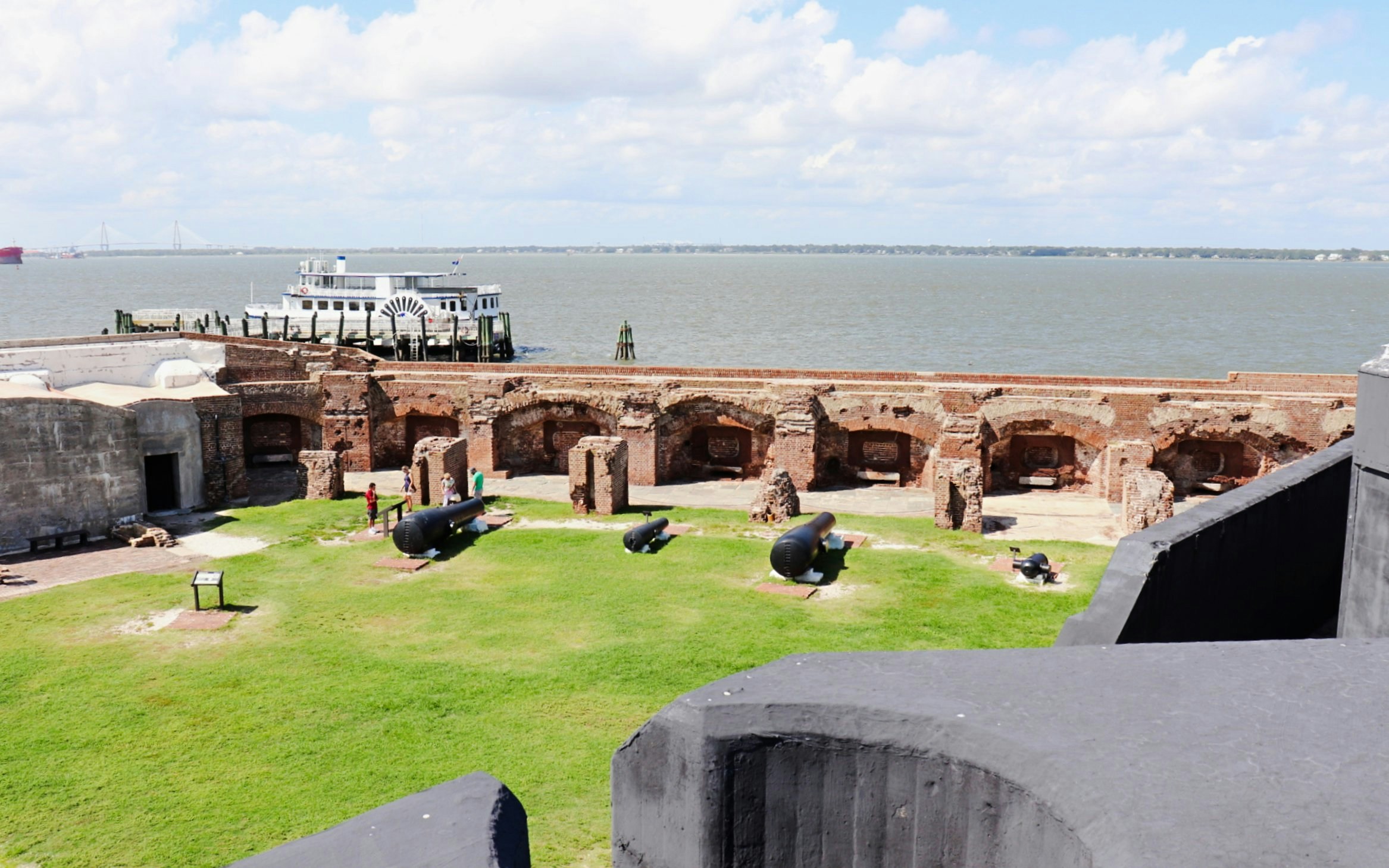 Fort Sumter with historic cannons and a ferry in Charleston Harbor.
