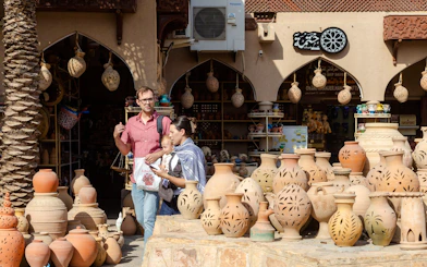 Nizwa pottery market with tourists exploring traditional clay pots, Oman.
