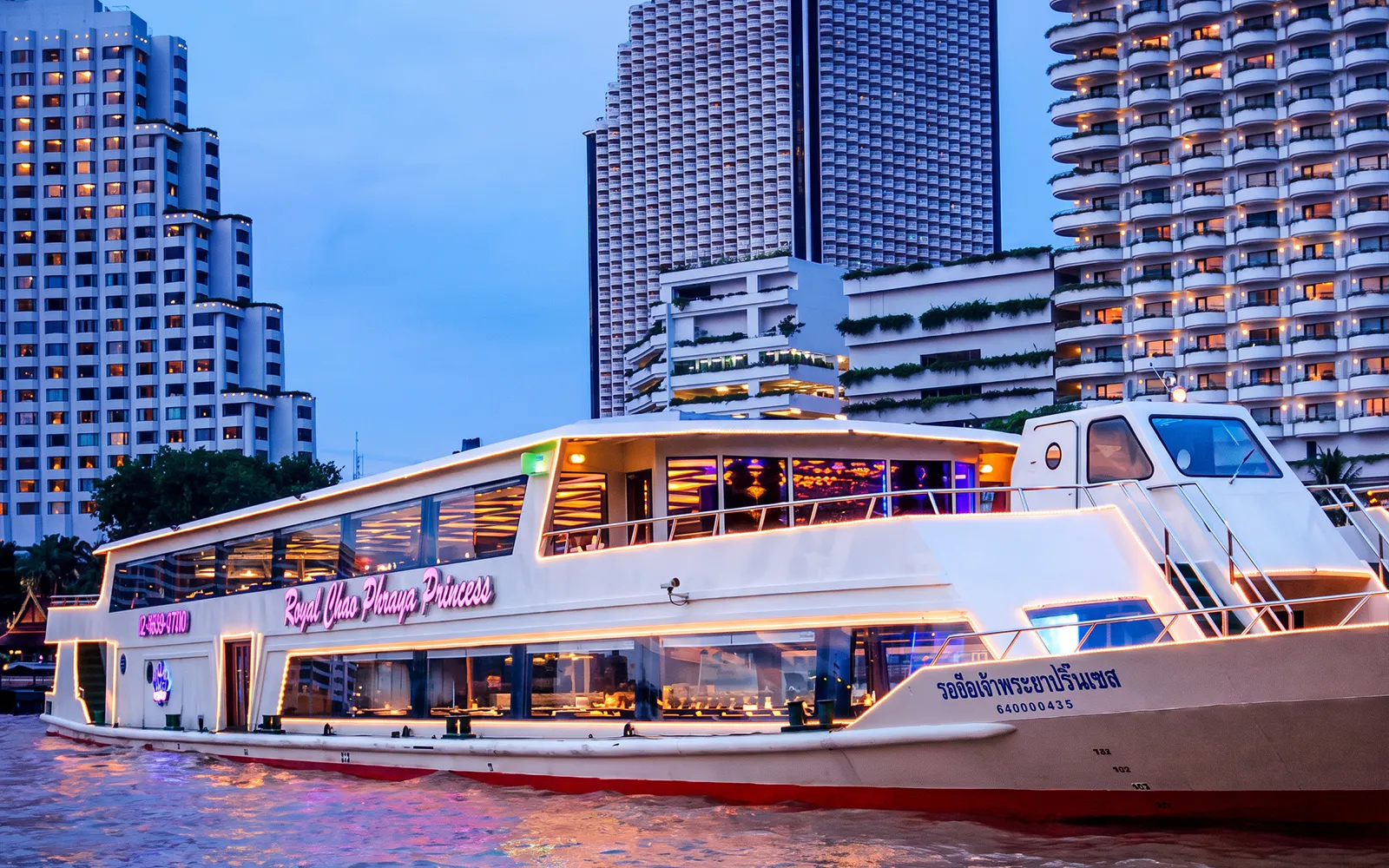 Chao Phraya Princess Cruise on river with cityscape backdrop in Bangkok.
