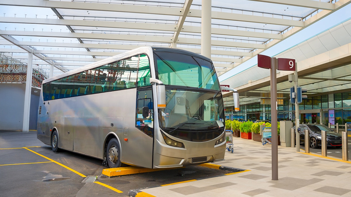 Public transport bus at a stop in Singapore under a modern canopy.