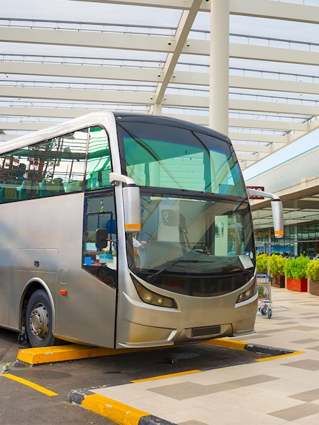 Public transport bus at a stop in Singapore under a modern canopy.
